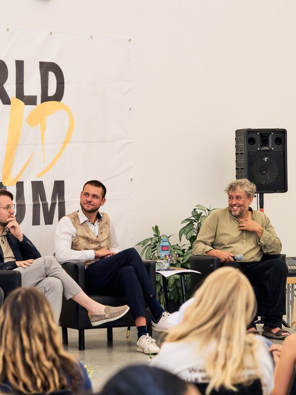 A panel conversation in front of the World Child Forum banner
