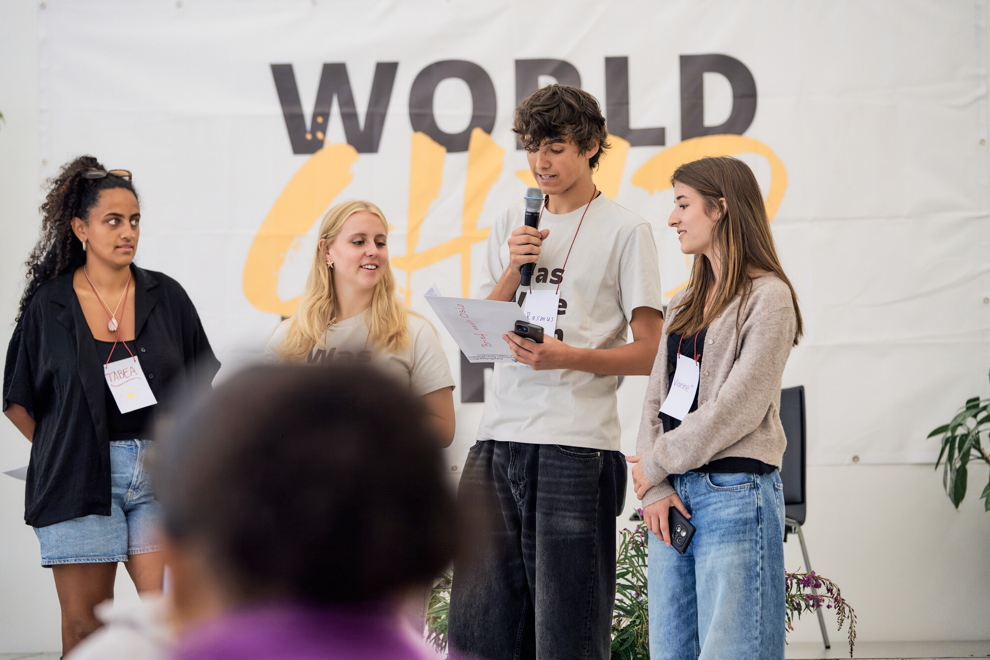 Children and young people on stage with adults in front of the World Child Forum banner