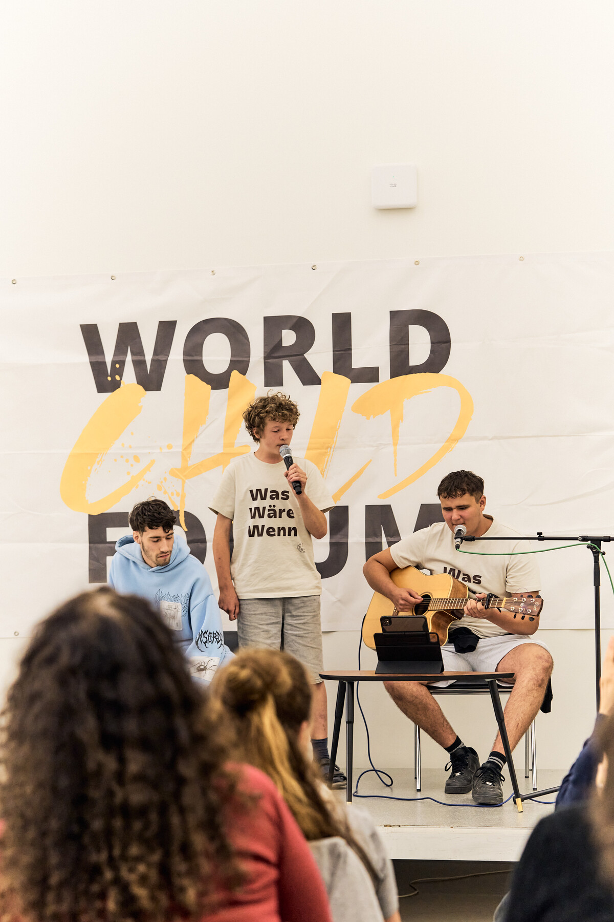 Young musicians perform in front of the World Child Forum banner