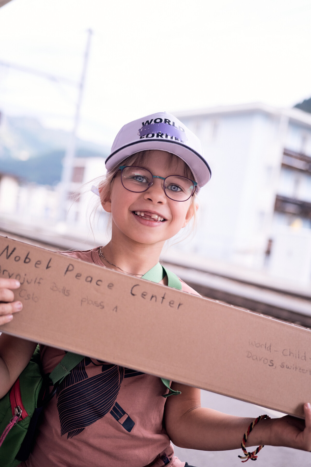 A young participant holds a cardboard sign addressed to the Nobel Peace Center
